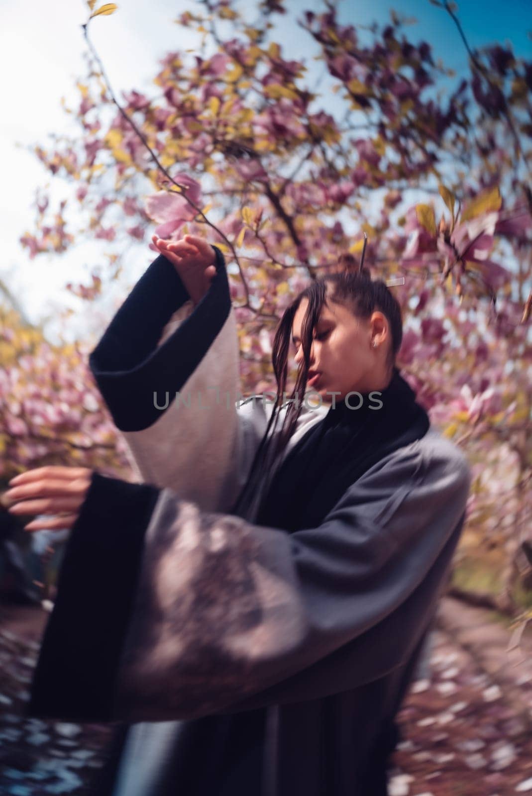 Beautiful dramatic young woman wearing kimono with cherry blossoms, sakura view. High quality photo