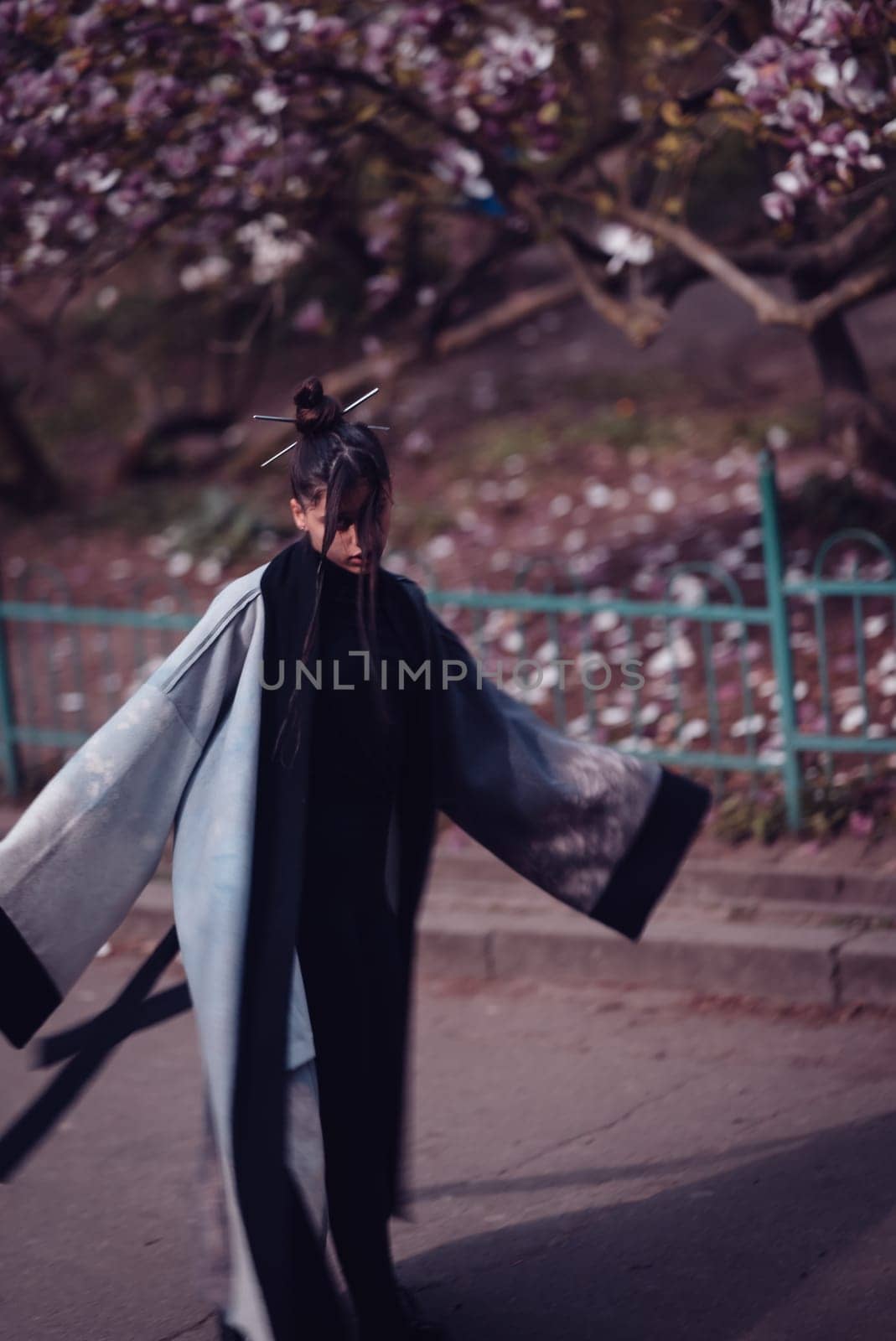 Beautiful dramatic young woman wearing kimono with cherry blossoms, sakura view. High quality photo