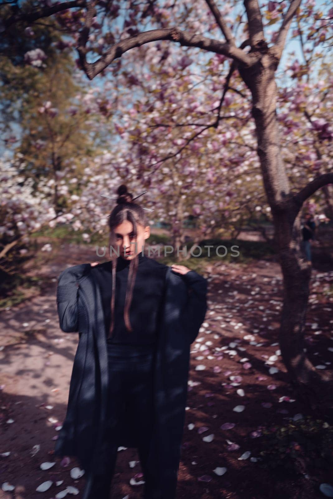 Beautiful dramatic young woman wearing kimono with cherry blossoms, sakura view. High quality photo