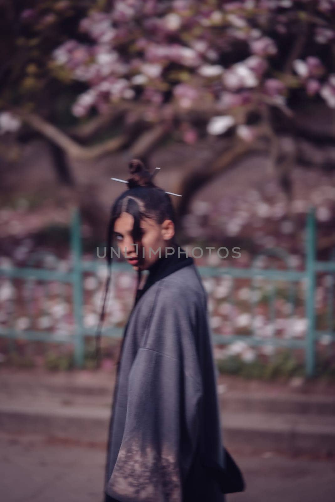 Beautiful dramatic young woman wearing kimono with cherry blossoms, sakura view. High quality photo