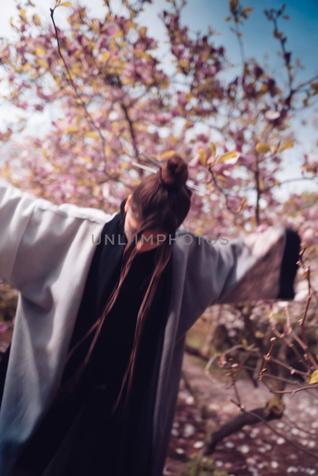 Beautiful dramatic young woman wearing kimono with cherry blossoms, sakura view. High quality photo
