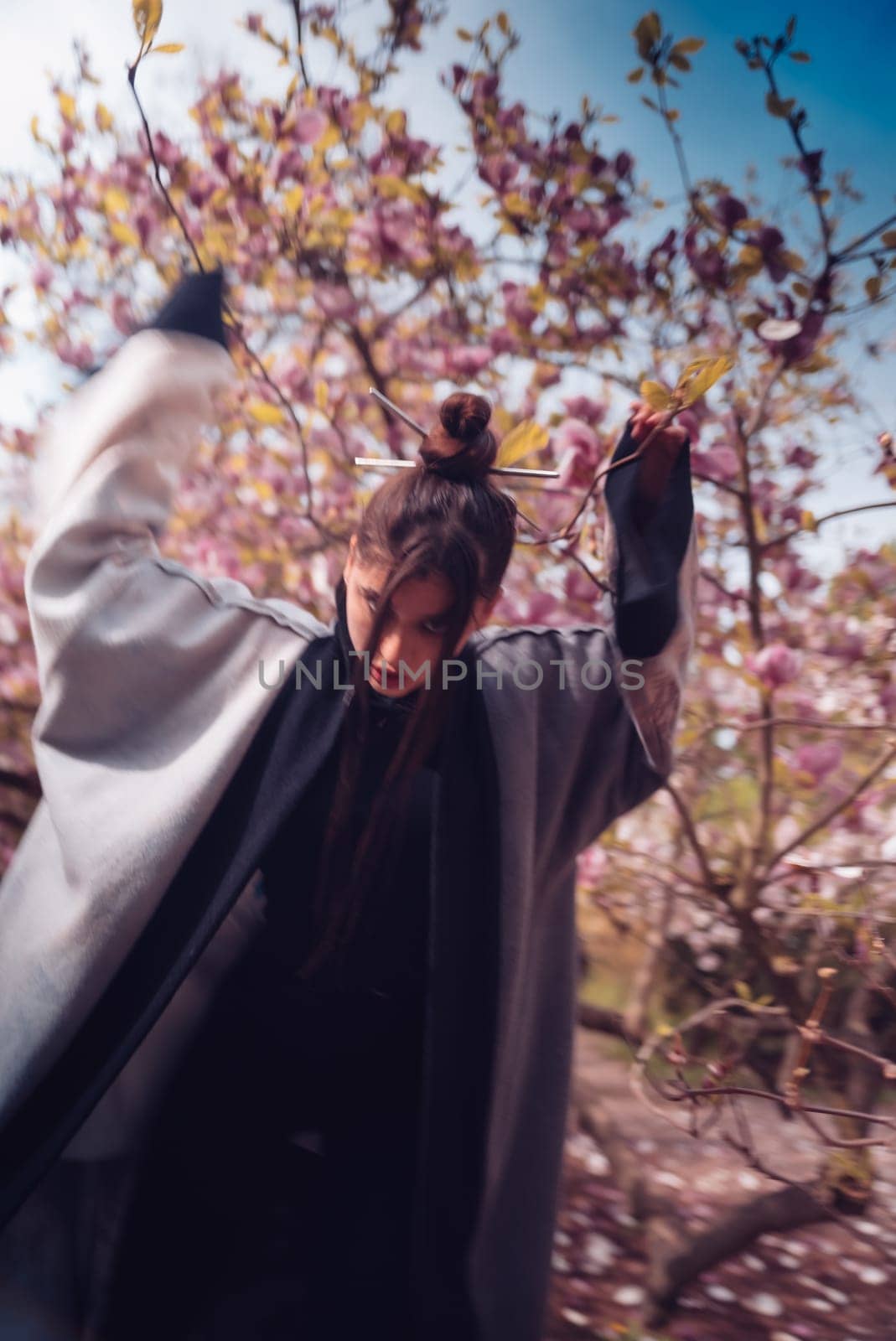 Beautiful dramatic young woman wearing kimono with cherry blossoms, sakura view. High quality photo