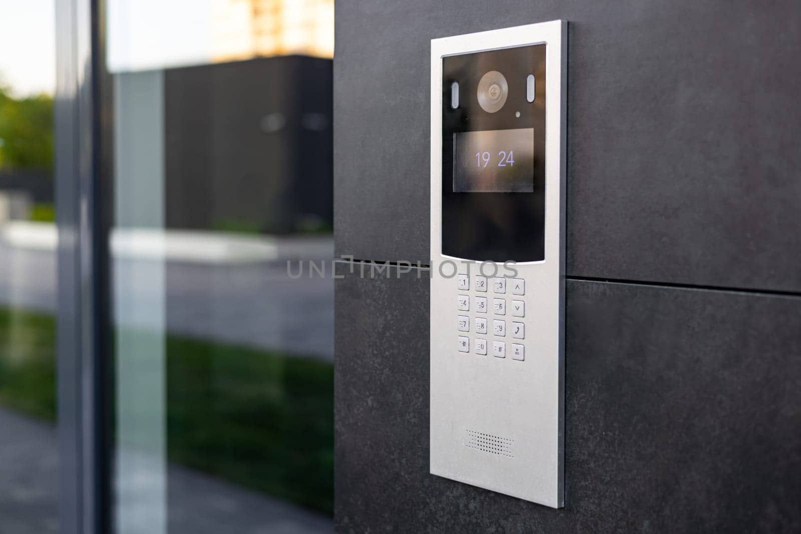 Entrance doorbell in a multi-apartment building, with a video surveillance camera, on a dark wall by voronaman