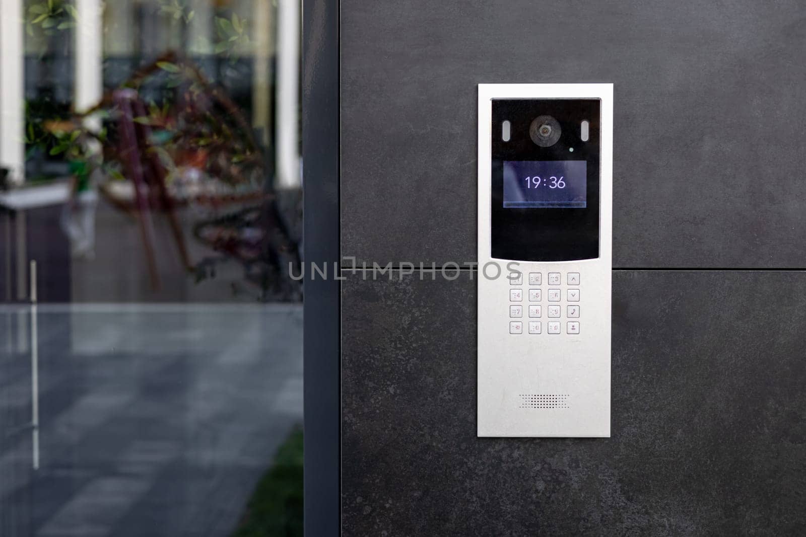 Entrance doorbell in a multi-apartment building, with a video surveillance camera, on a dark wall by voronaman