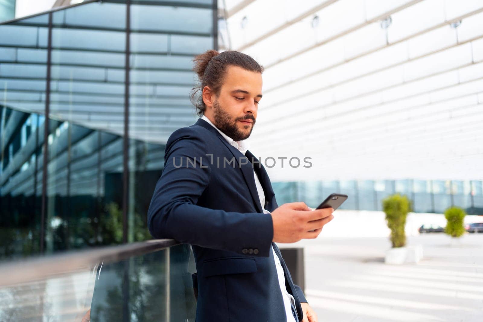 Businessman standing outdoor use smartphone looking device screen confident. Handsome hispanic male business person middle age dressed business suit holding smartphone in hand. Modern business person