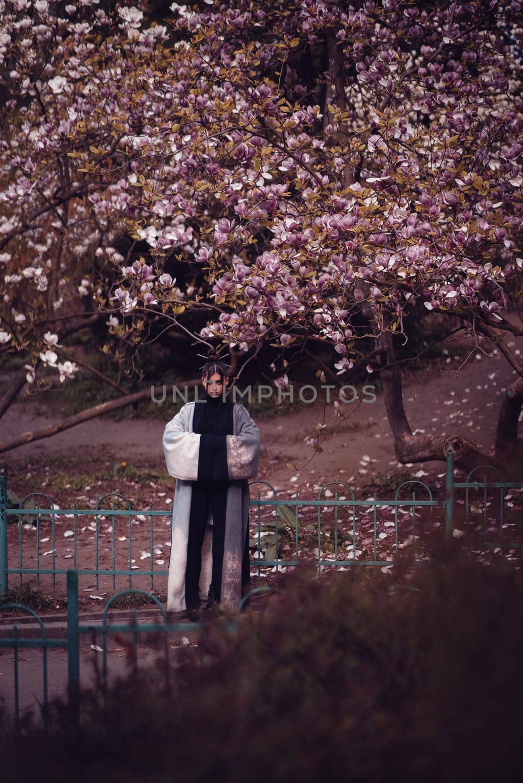 Beautiful dramatic young woman wearing kimono with cherry blossoms, sakura view. High quality photo