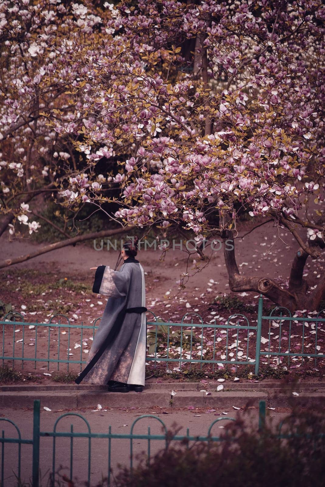 Beautiful dramatic young woman wearing kimono with cherry blossoms, sakura view. High quality photo