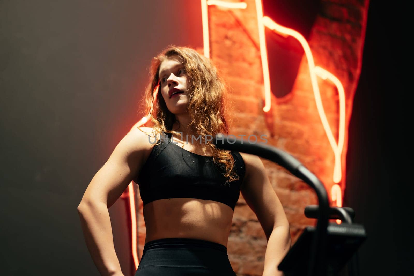 young beautiful woman on elliptical orbitrek machine in fitness gym.