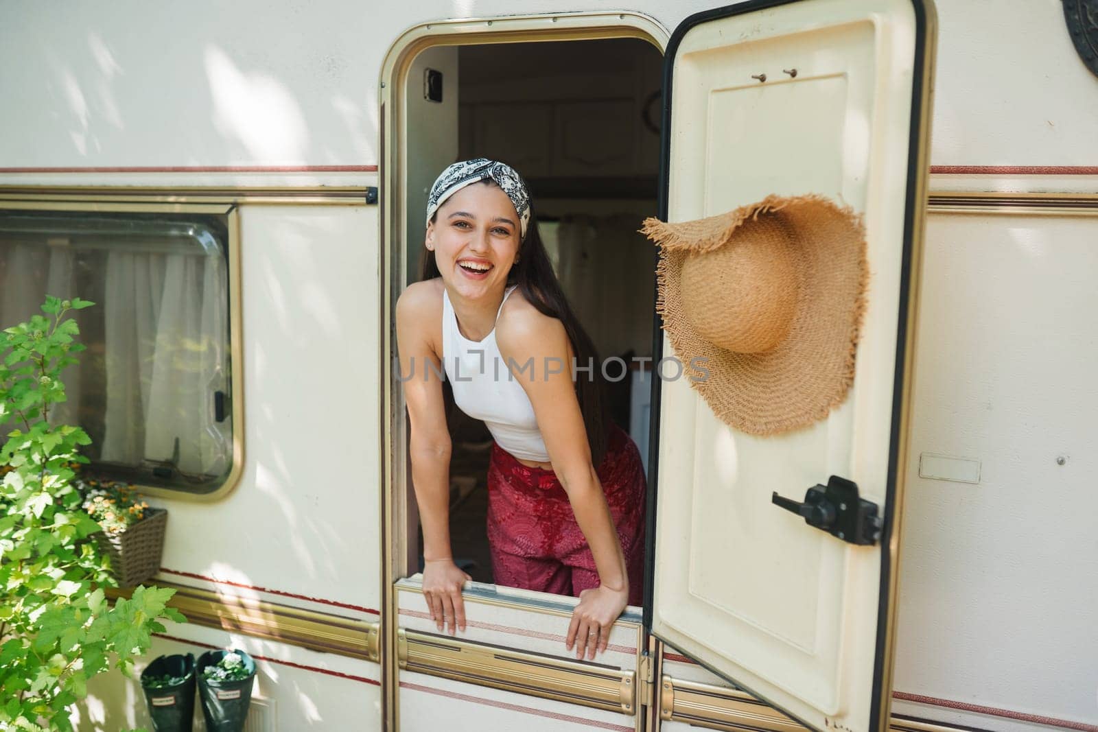 Happy hippie girl are having a good time in a camper trailer. Holiday, vacation, trip concept.High quality photo