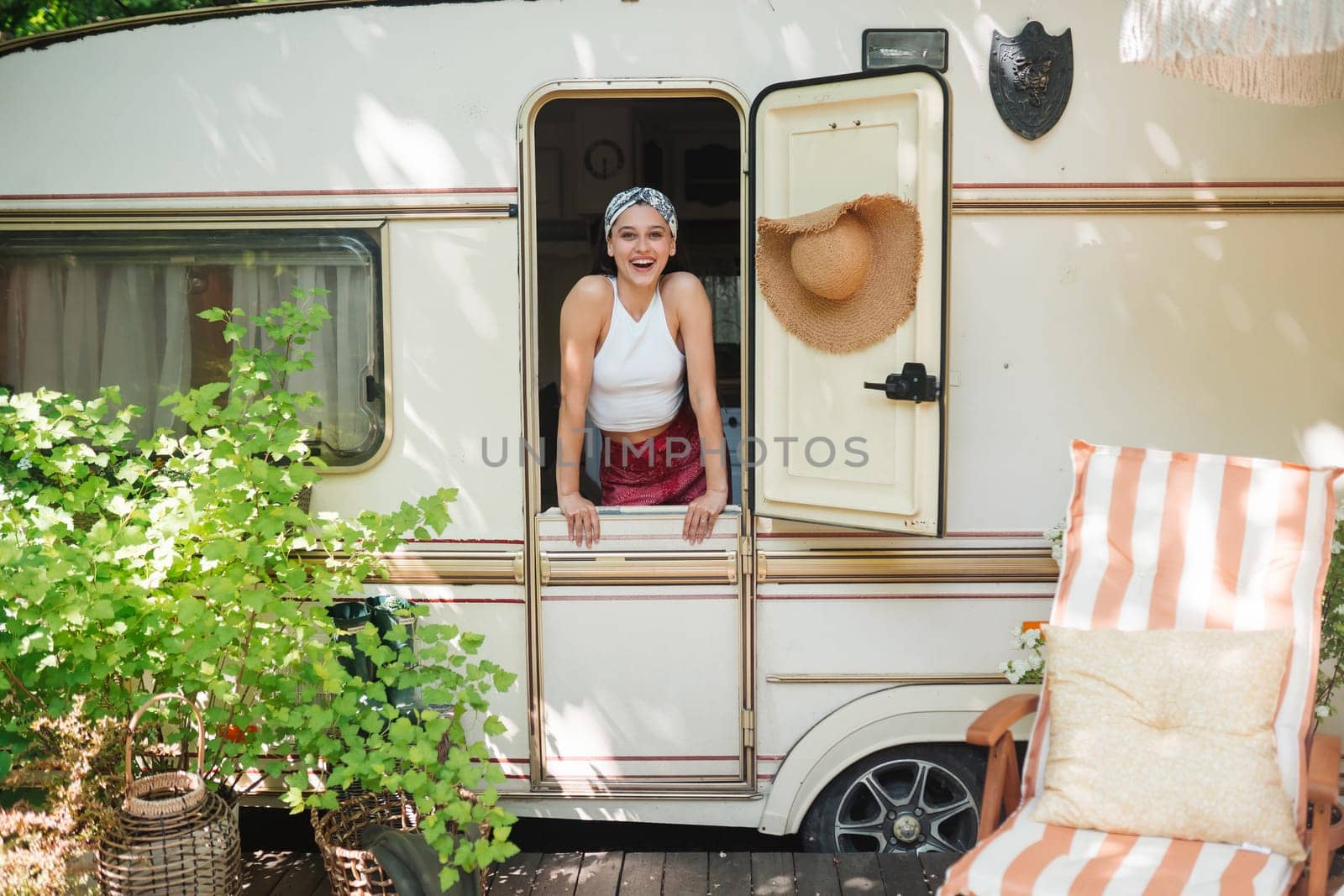 Happy hippie girl are having a good time in a camper trailer. Holiday, vacation, trip concept.High quality photo