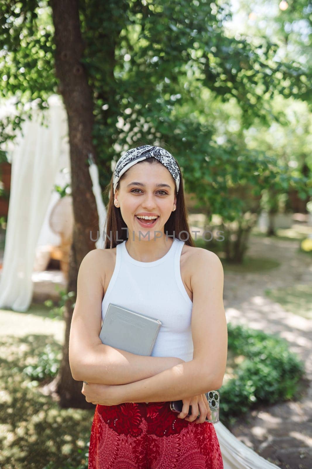 Happy hippie girl with book in her hands is having a good time with playing in camper trailer. Holiday, vacation, trip concept.High quality photo