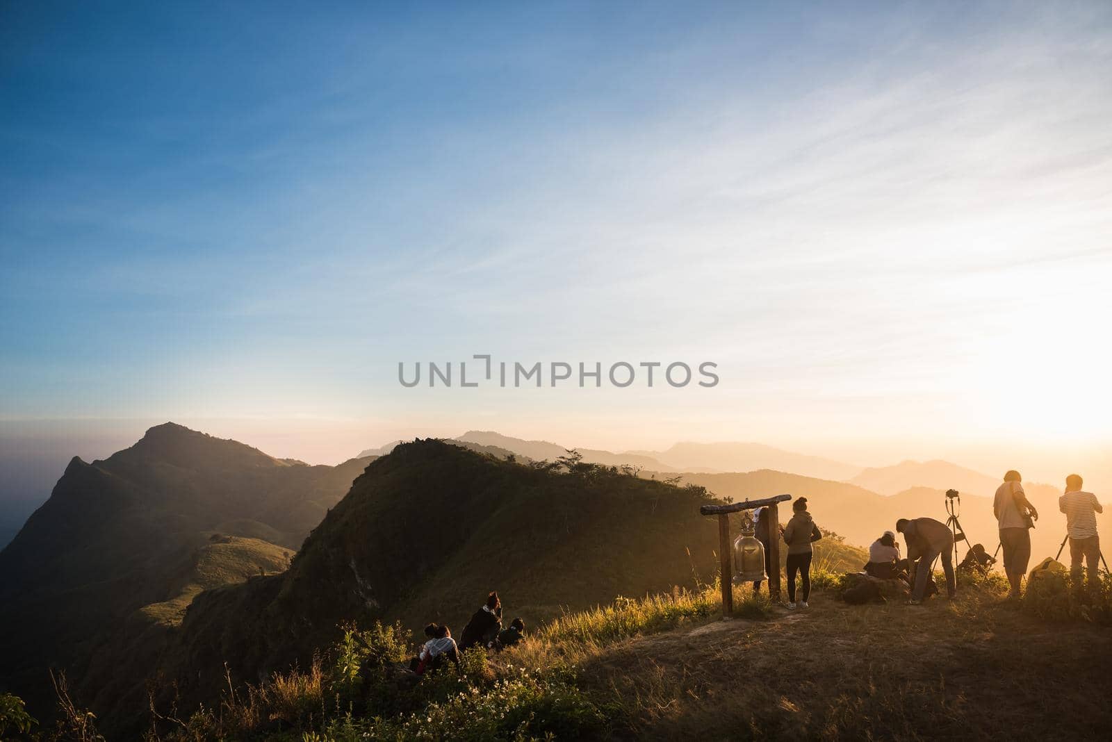 tourists with taking photo of a valley from top of a mountain by Wmpix