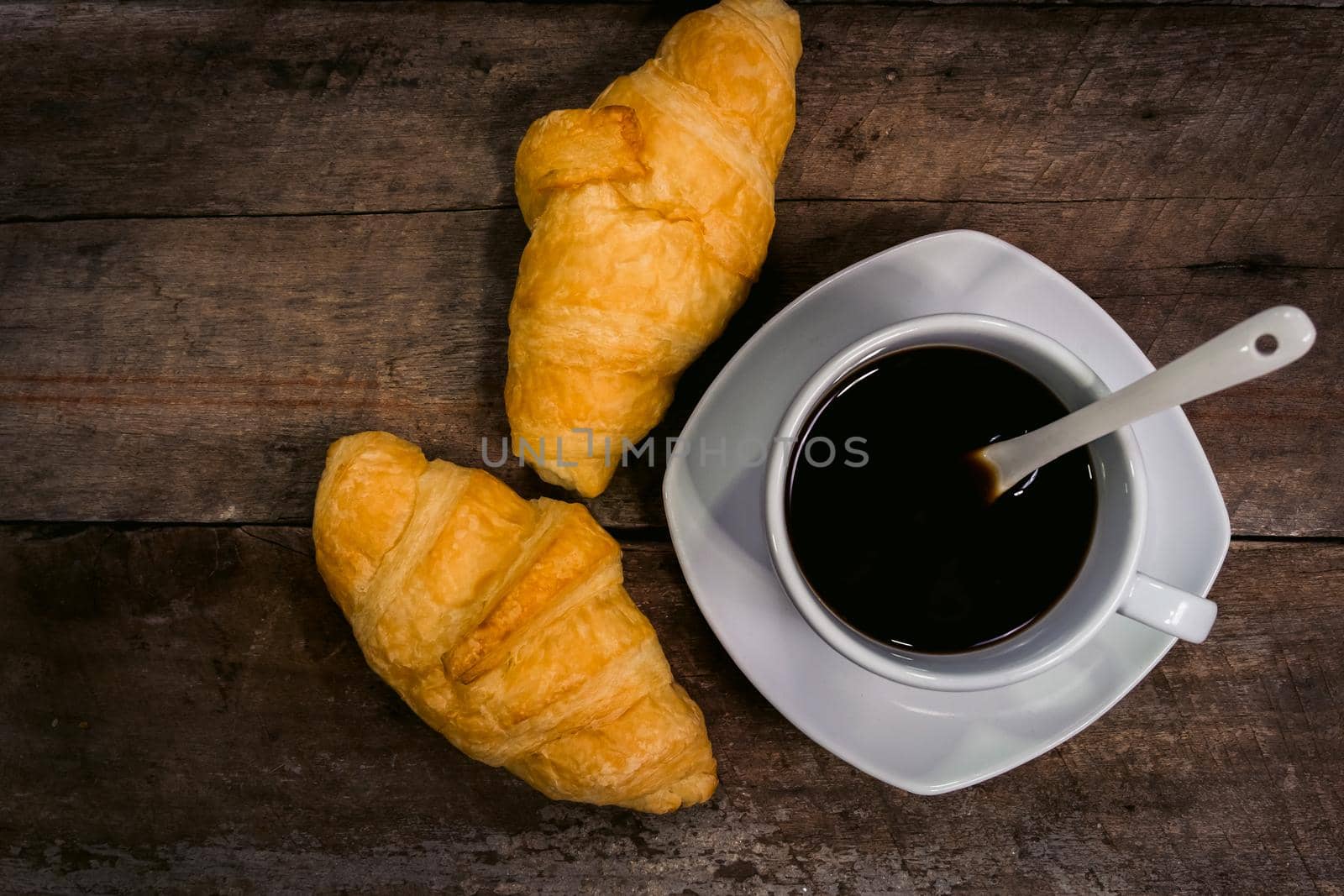 vintage croissants and black coffee composition on wooden background. Flat lay