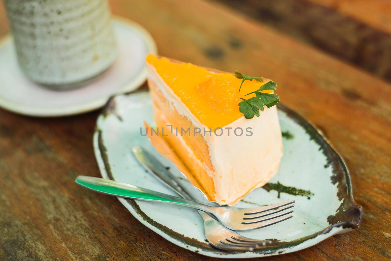 orange cake with ice coffee on wood table
