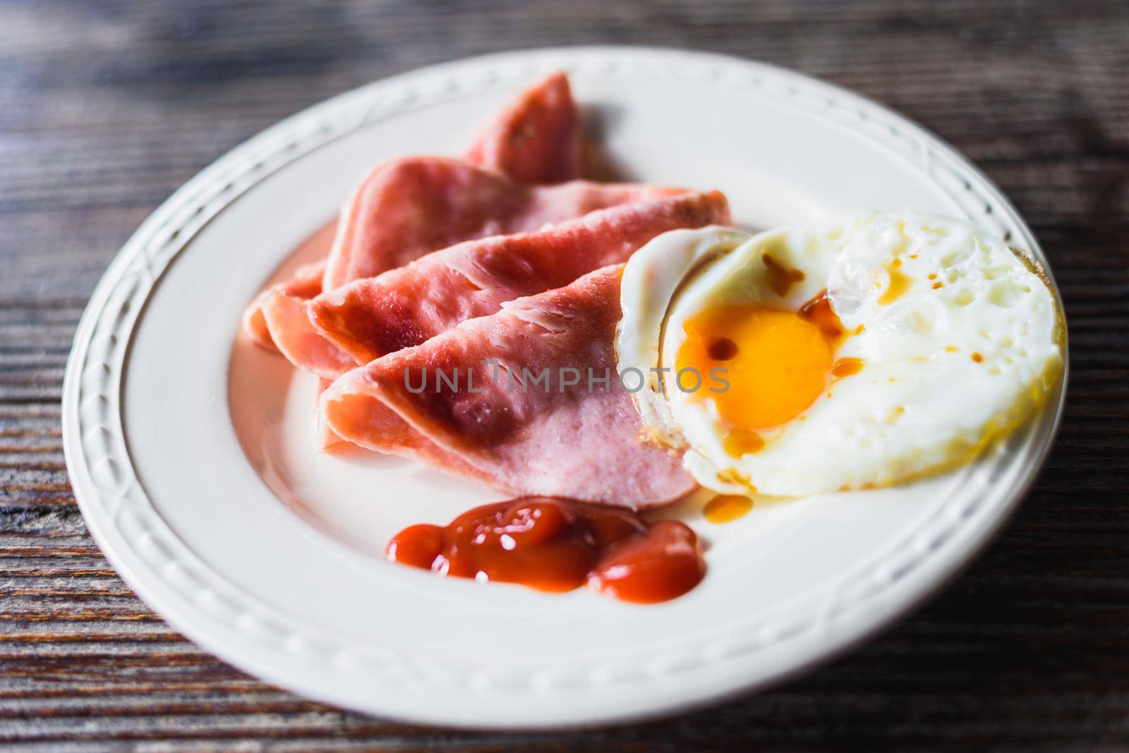 Fried Eggs and ham on a dish by Wmpix