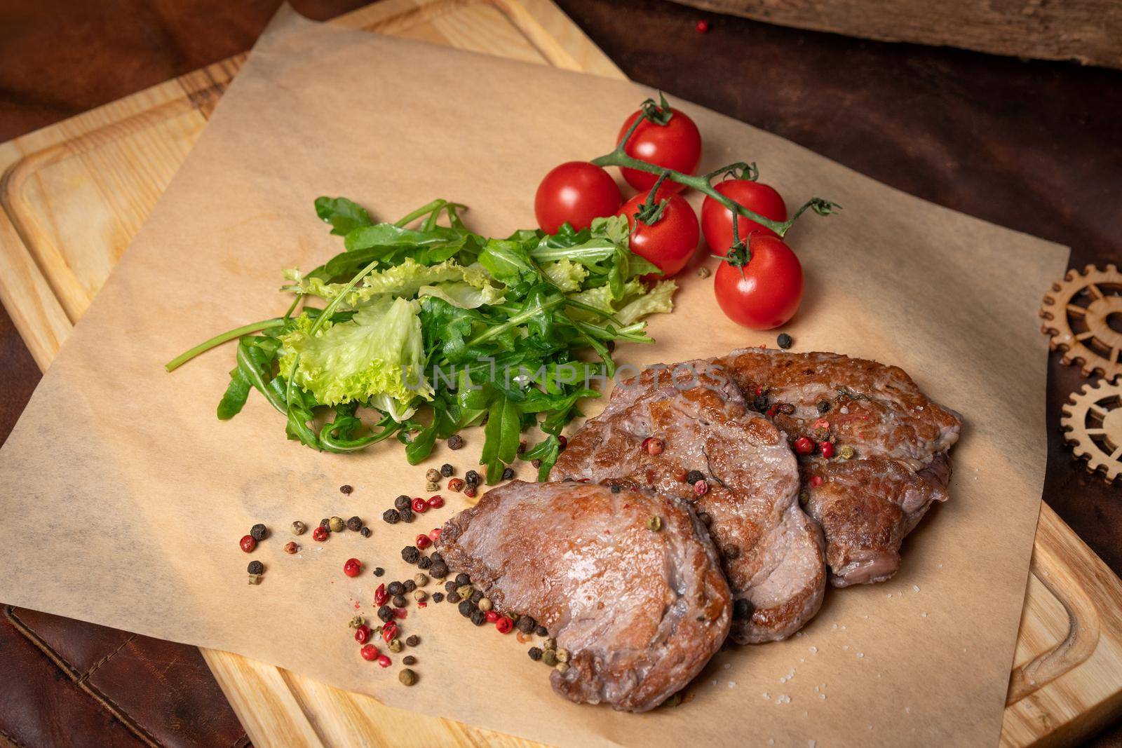 Pork fillets served with lettuce salad with arugula-seeded pepper mixture and cherry tomatoes,. Restaurant concept. Restaurant food. Grill concept. 