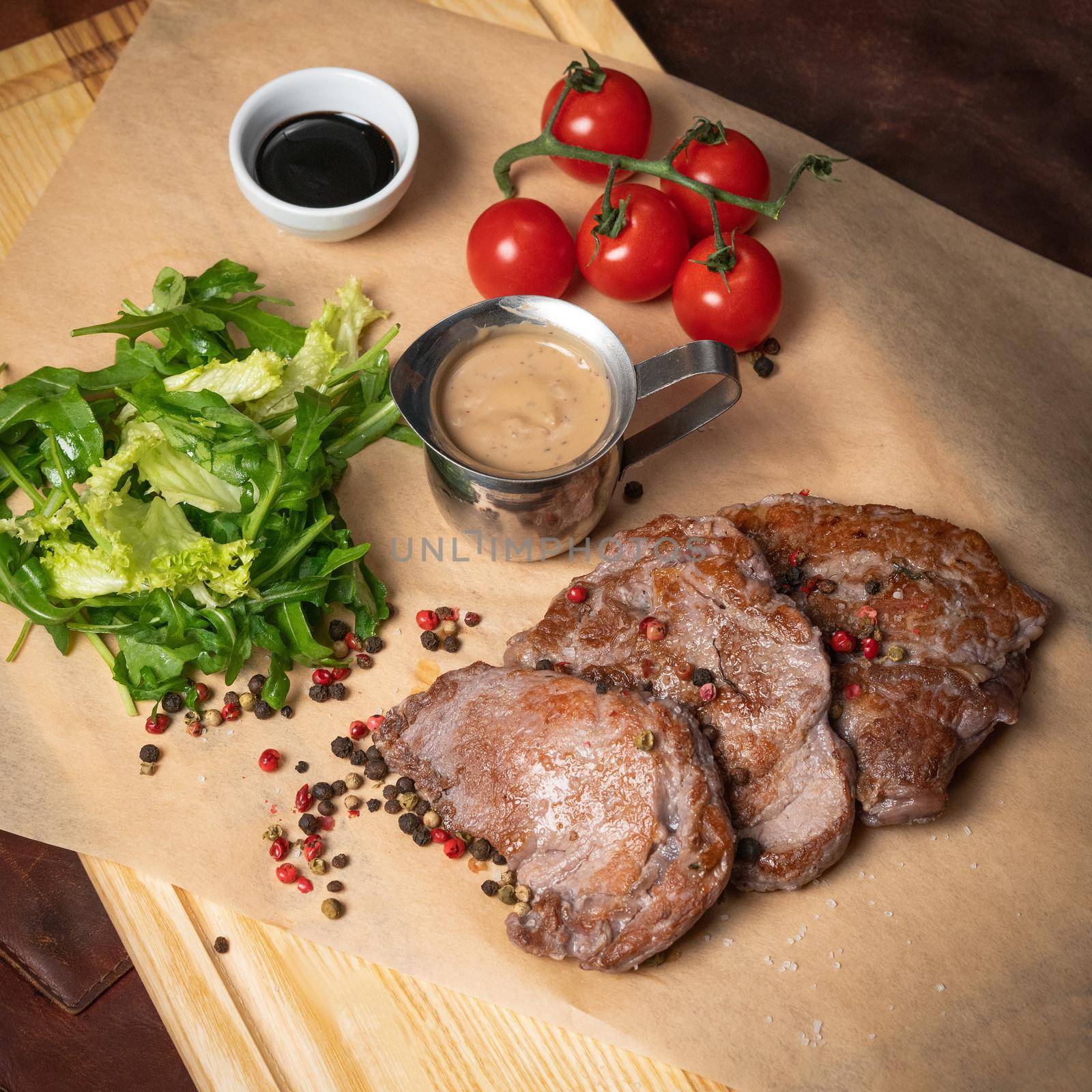 Fresh pork fillets served with lettuce salad with arugula-seeded pepper mixture and cherry tomatoes,. Restaurant concept. Restaurant food. Grill concept. 