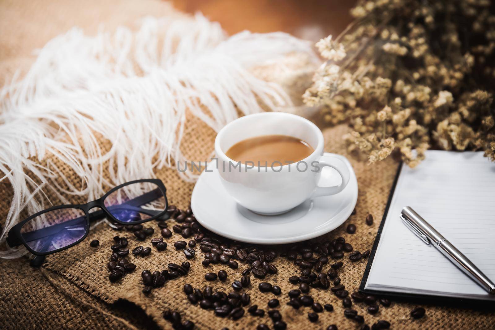 Coffee cup and coffee beans on wood table