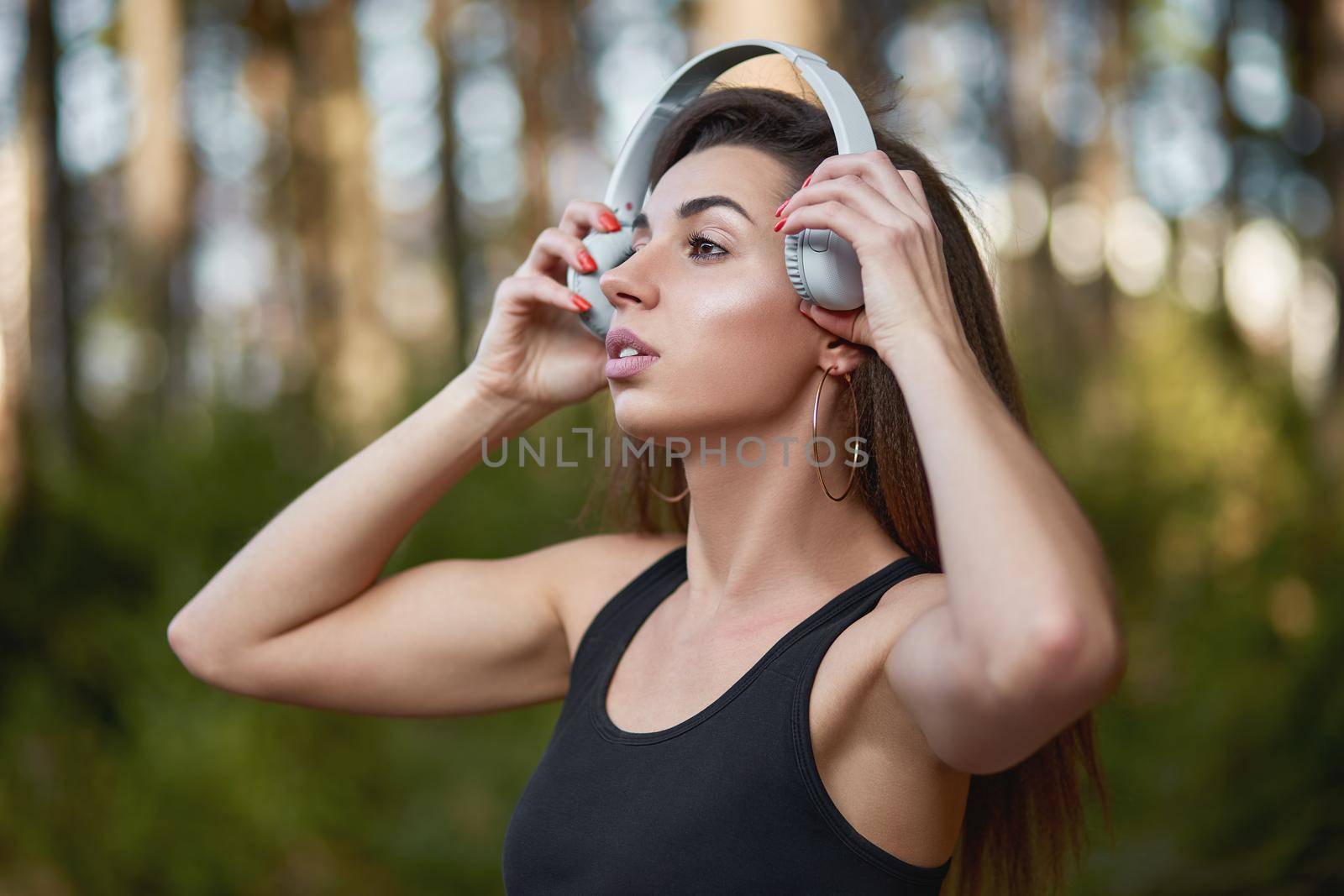 Young woman listening to music in the forest. by AliaksandrFilimonau