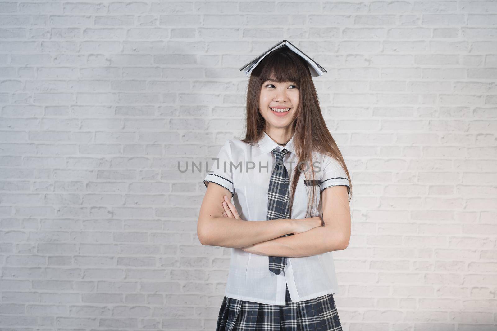 Portrait of cute student girl wearing japan uniform on gray background