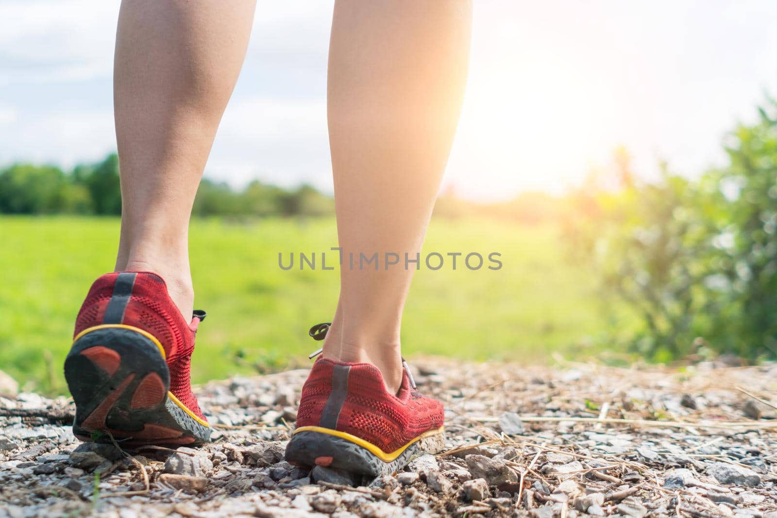 Woman wear running shoe on to walking and running on nature green background.Health exercise concept.