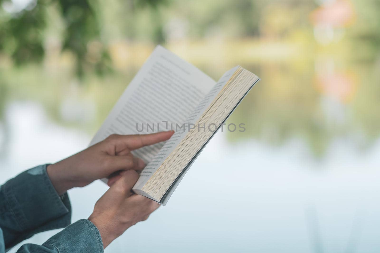 Woman is reading book in beautiful park and pond relax and peaceful environment by Suwant