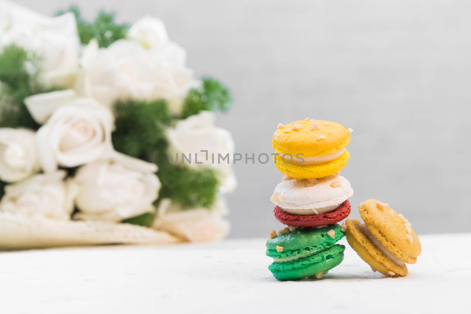 colourful french macaroons with white rose on white background by Wmpix