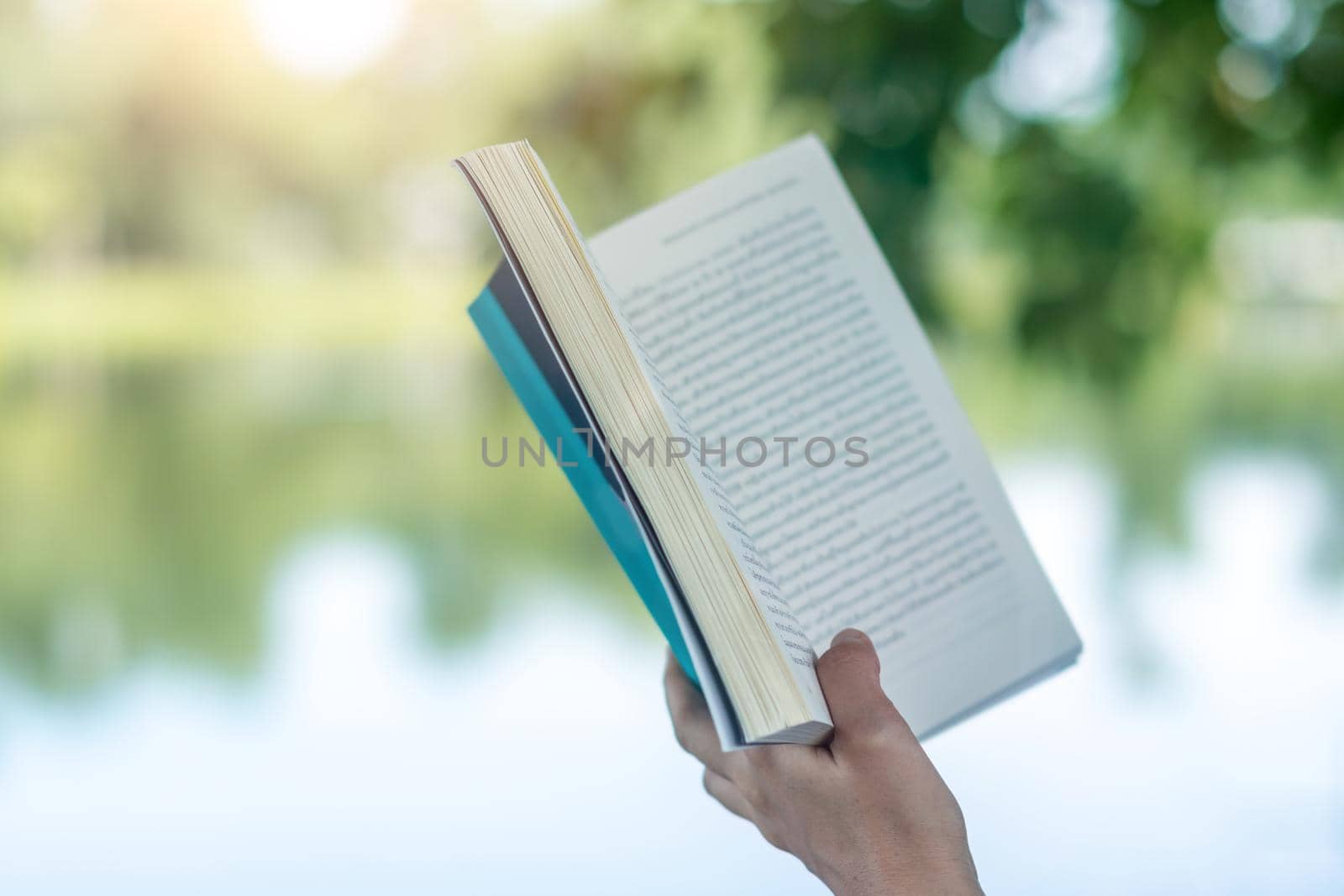 Woman is reading book in beautiful park and pond relax and peaceful environment by Suwant