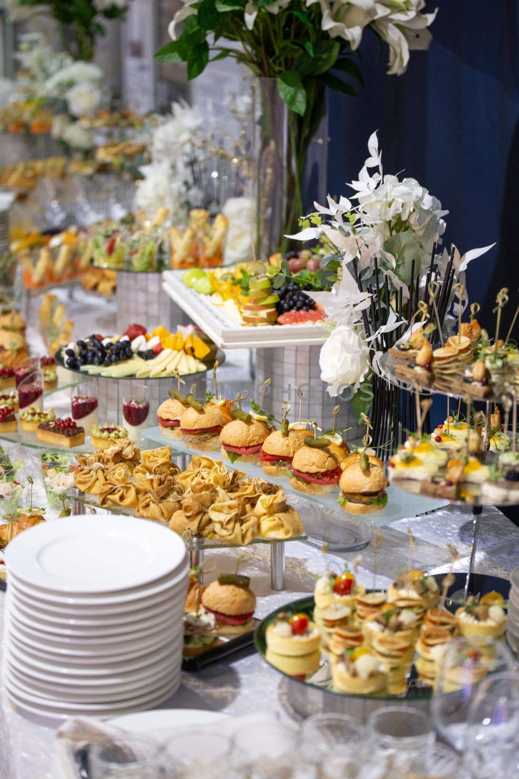 various snacks and drinks at the buffet table at the corporate catering event by Pukhovskiy