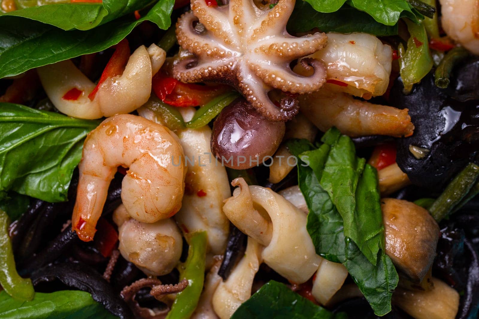 top view seafood salad in a blue plate in a restaurant. Shrimp, octopus squid close-up.