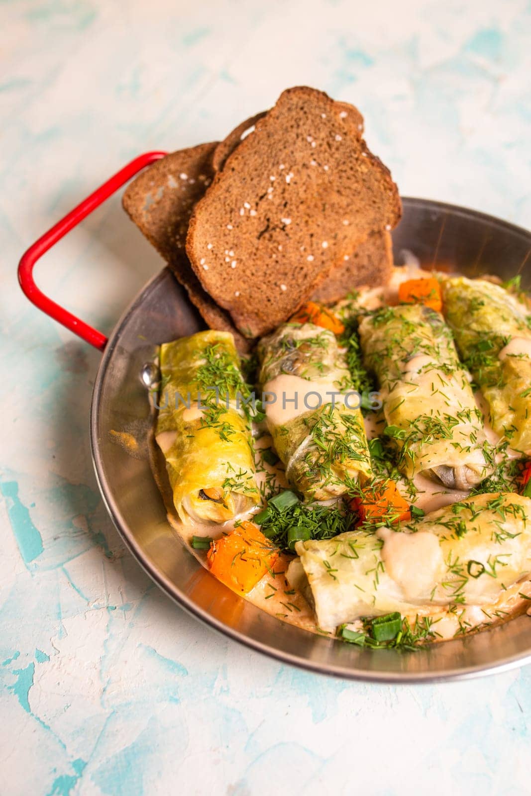 top view cabbage rolls in metal dishes on a blue background