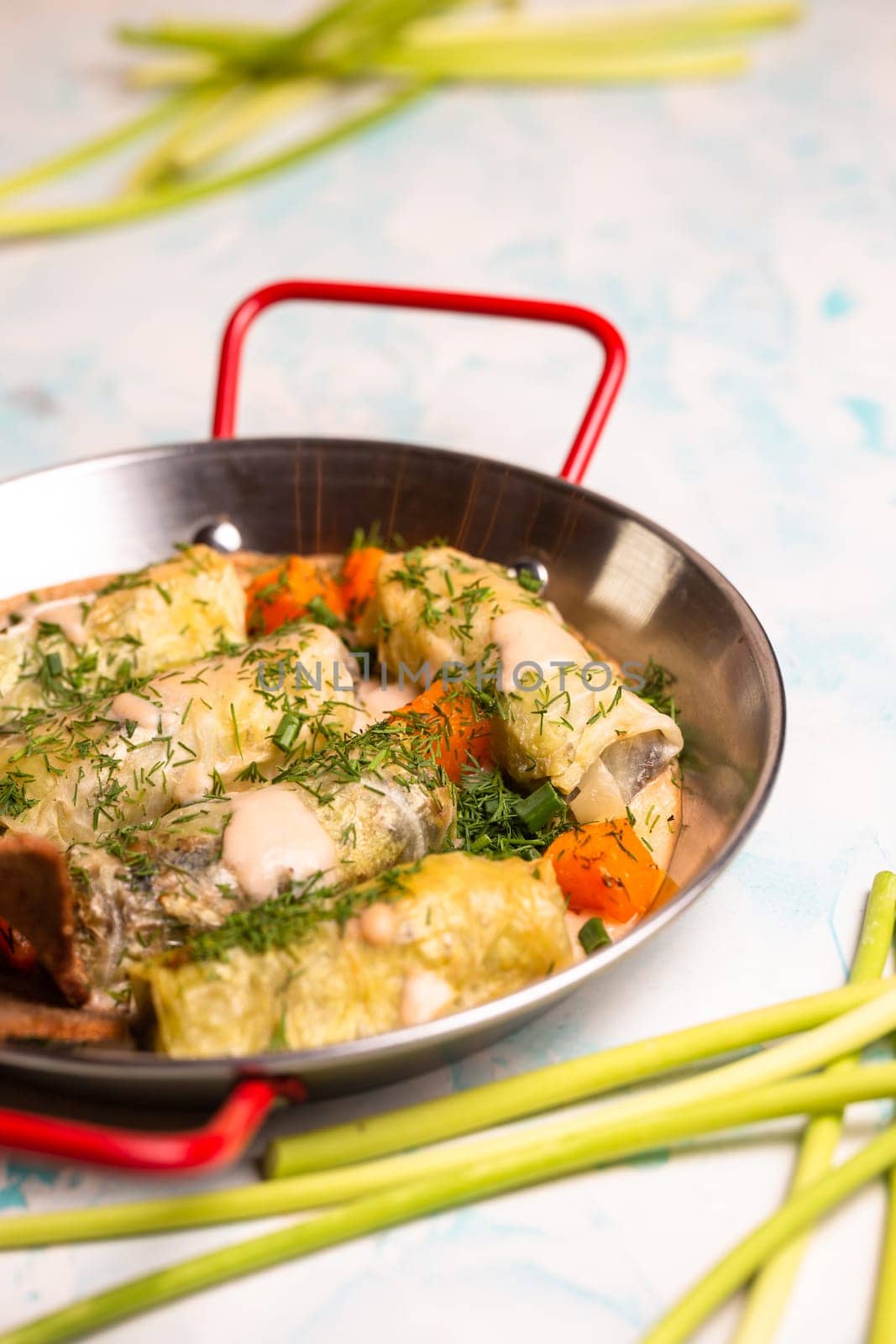 delicious cabbage rolls in a frying pan with a piece of rye bread.