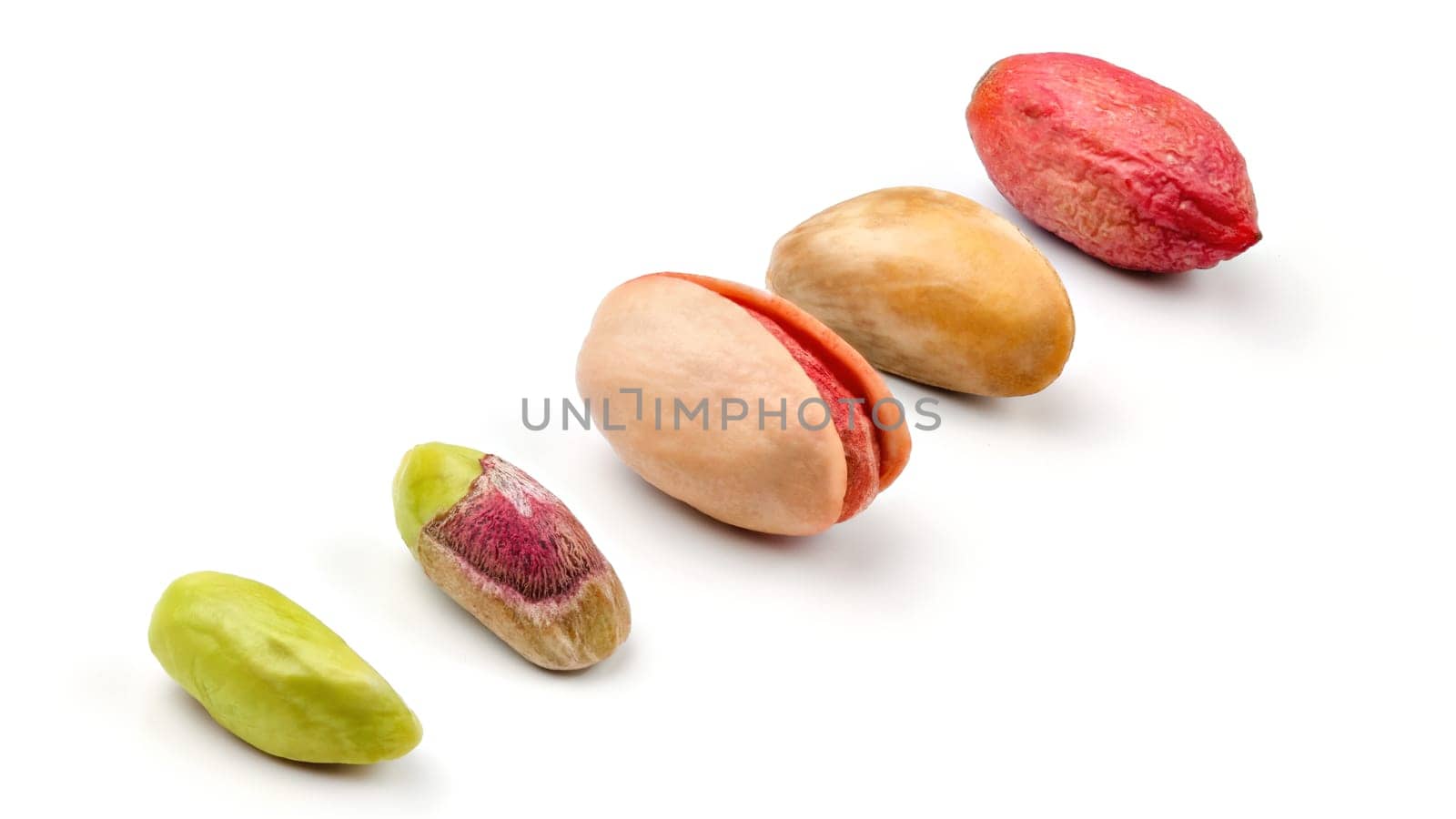 Pistachios in different stages from peeled green fruit, through roasted and salted to raw in purple skin, isolated on white background.