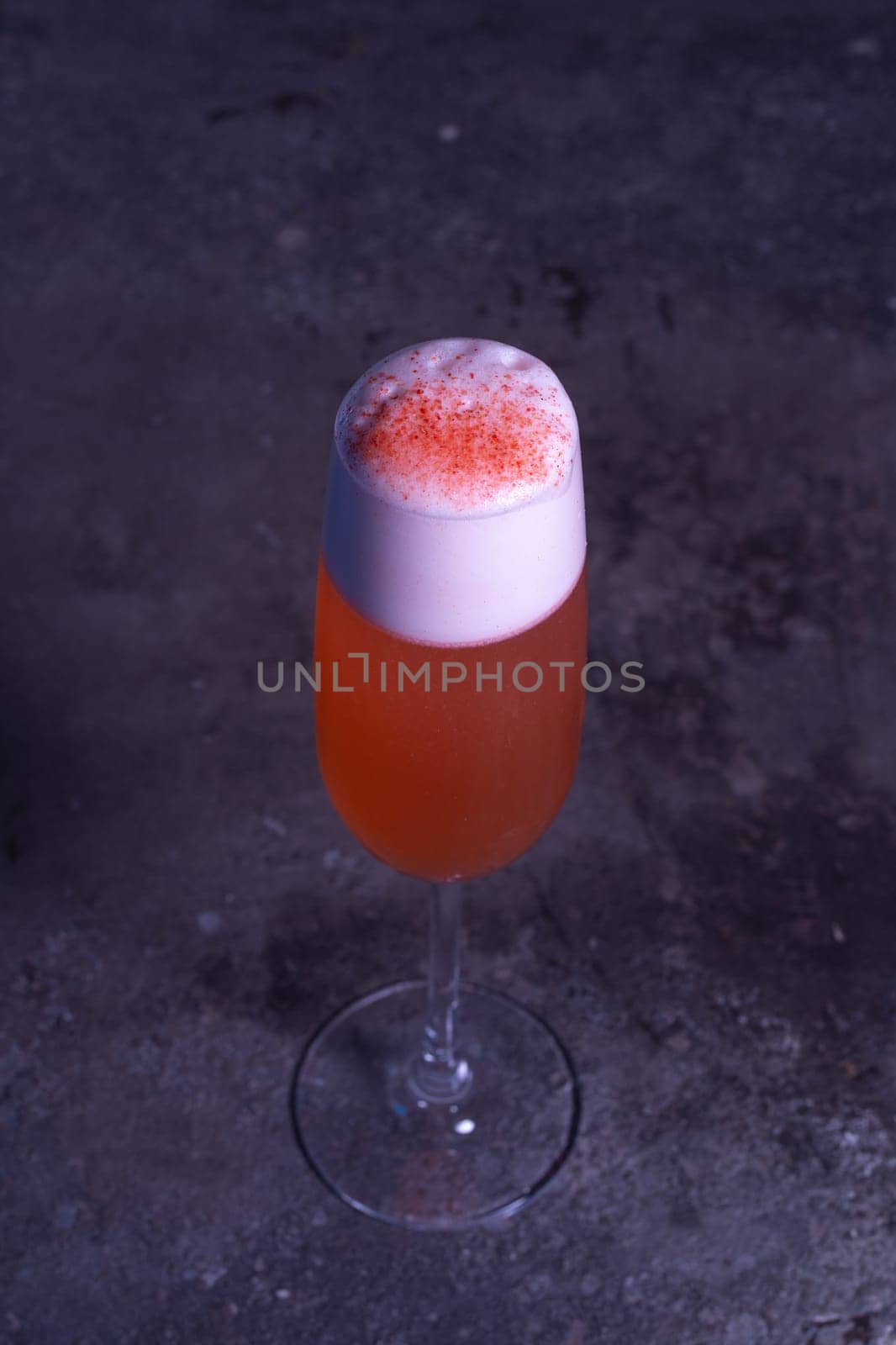 top view of an orange summer cold cocktail on a gray background by Pukhovskiy