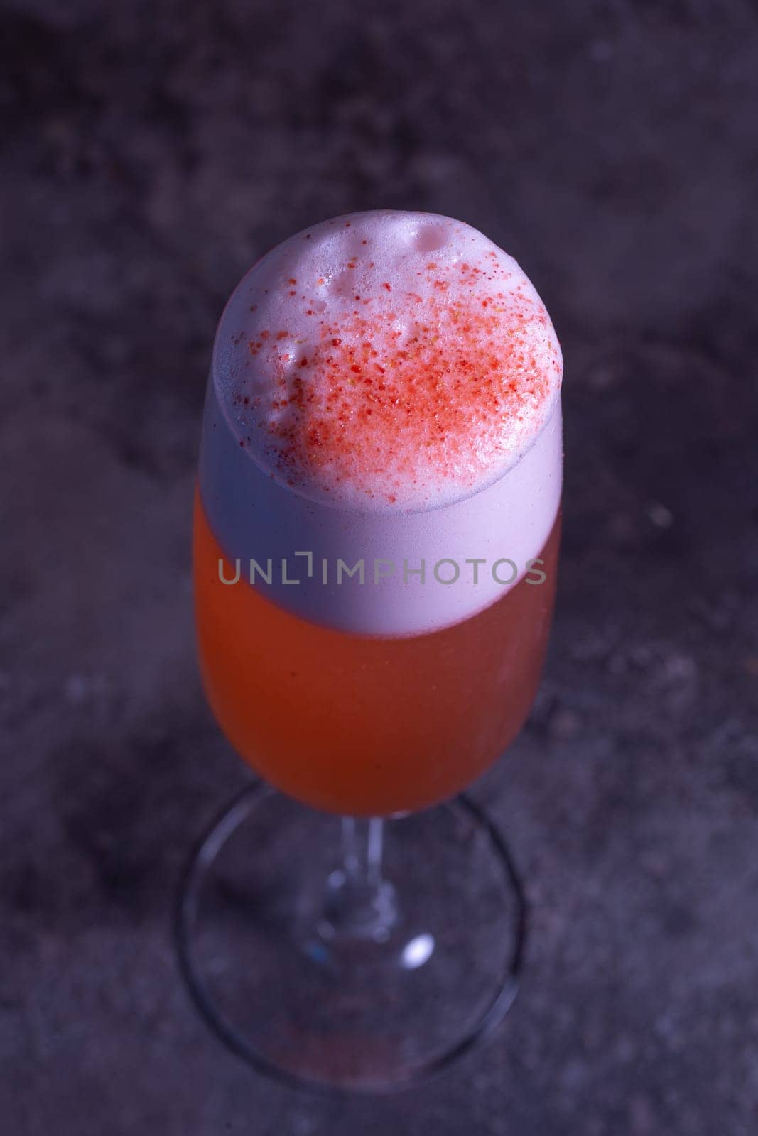 top view of an orange summer cold cocktail on a gray background by Pukhovskiy