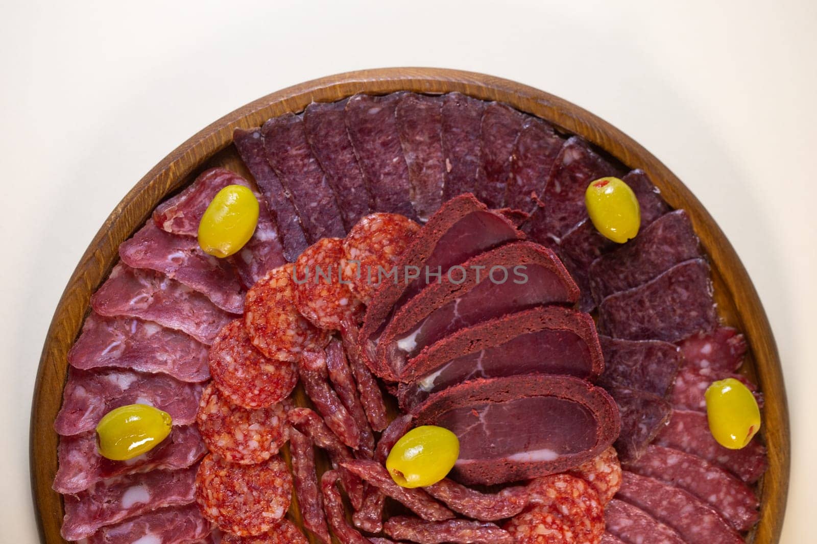 meat sliced from delicacies on a wooden stand top view.