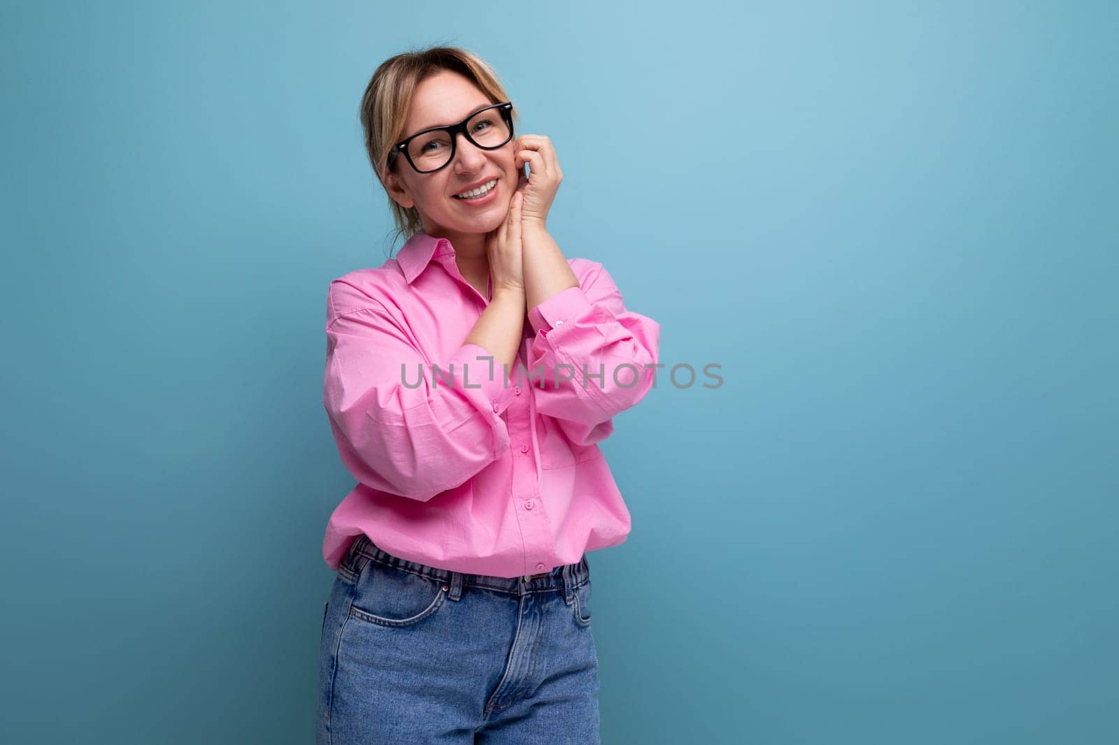 young smart successful caucasian blond leader woman with ponytail with glasses wearing pink blouse on studio isolated background with copy space.