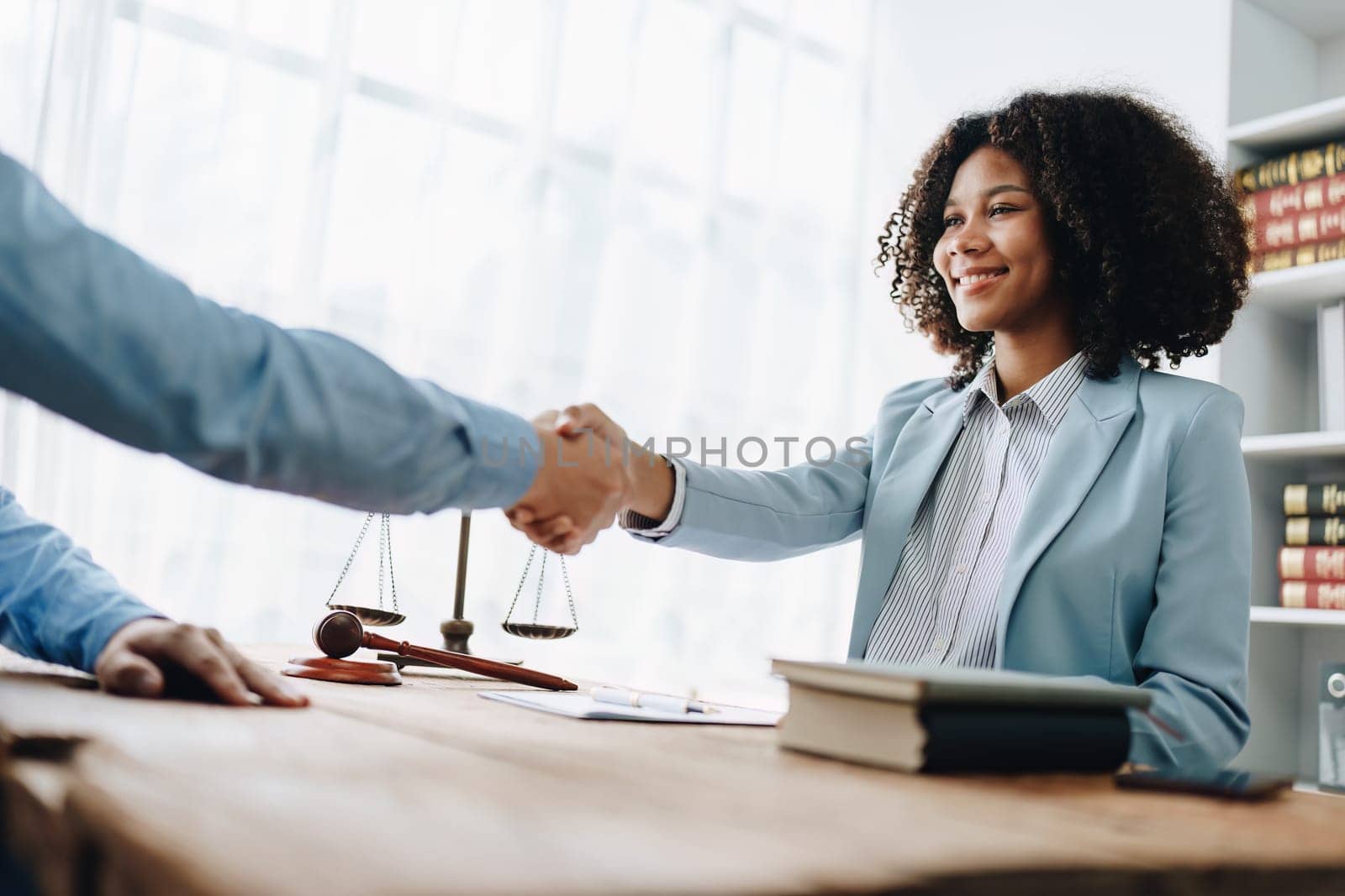 Law, consultation, agreement, contract, lawyer or attorney shakes hands to agree on the client's offer to be hired to fight the parties in court. by Manastrong