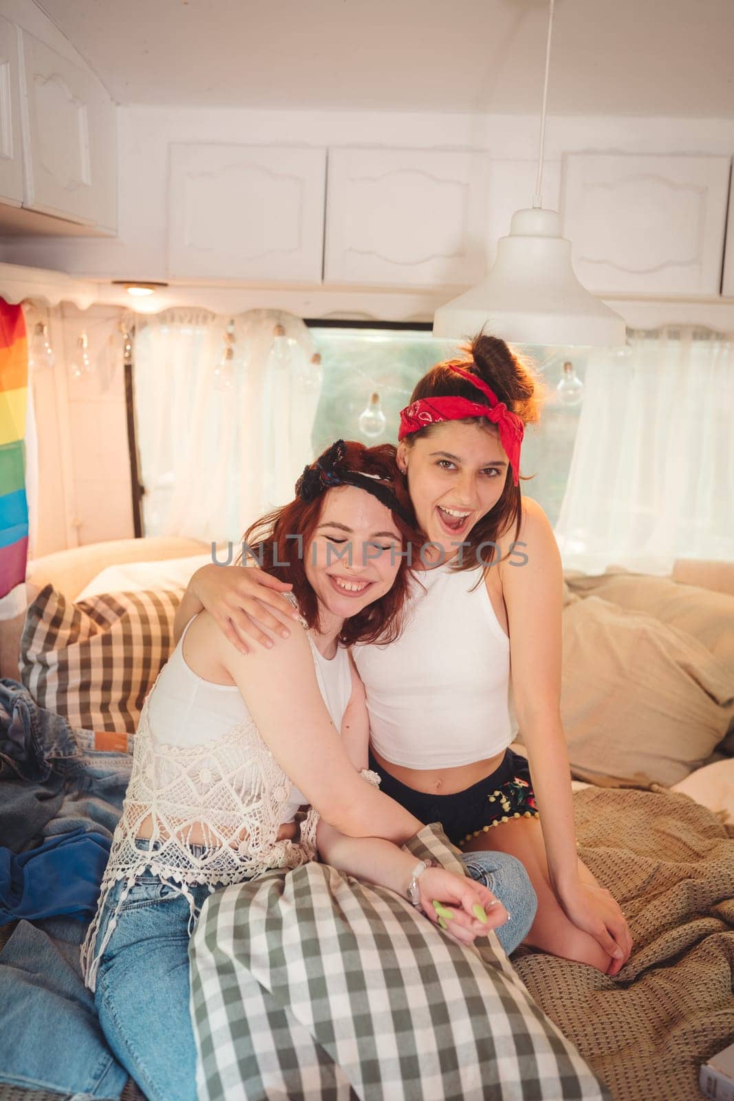 Portrait of a cute lesbian couple. Two girls spend time tenderly together in a camper trailer. Love and attitude. LGBT concept by teksomolika