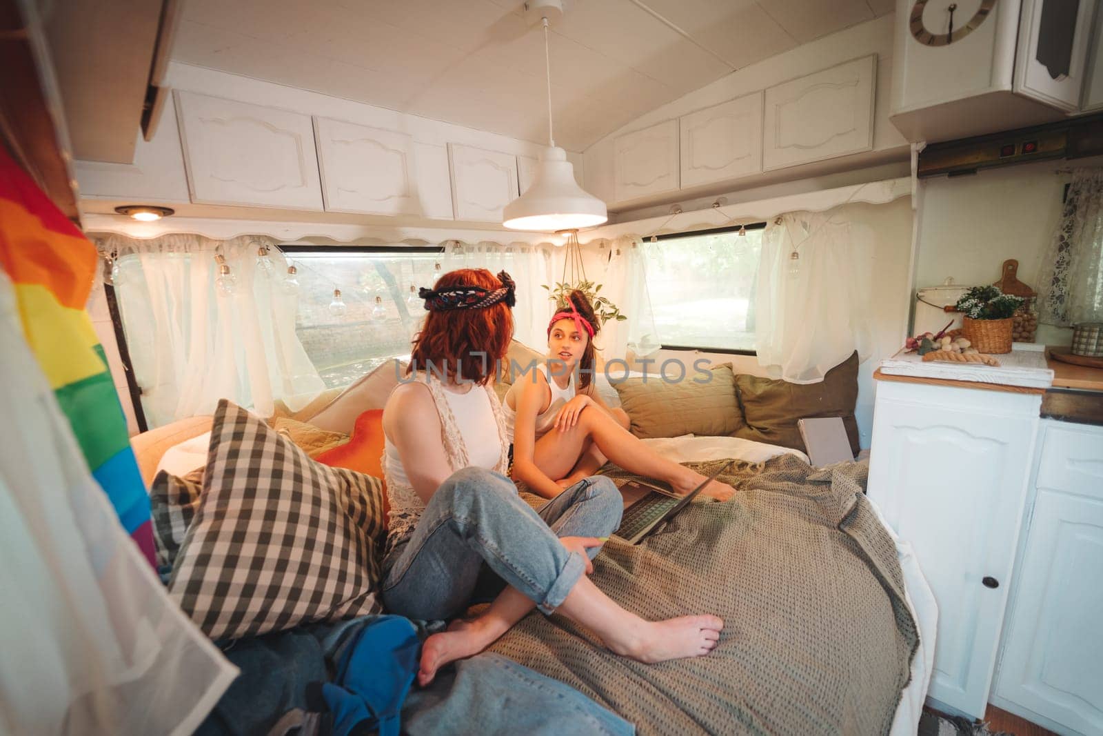 Portrait of a cute lesbian couple. Two girls spend time tenderly together in a camper trailer. Love and attitude. LGBT concept by teksomolika