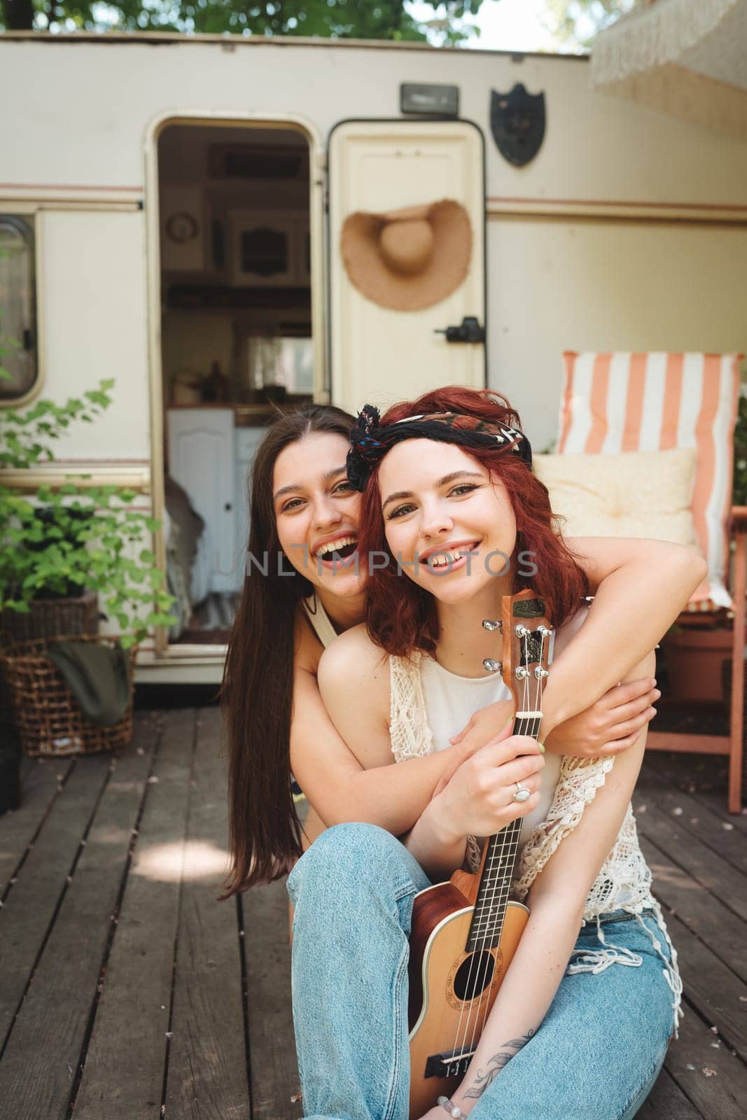 Happy hippie friends are having a good time together in camper trailer. Holiday, vacation, trip concept. High quality photo