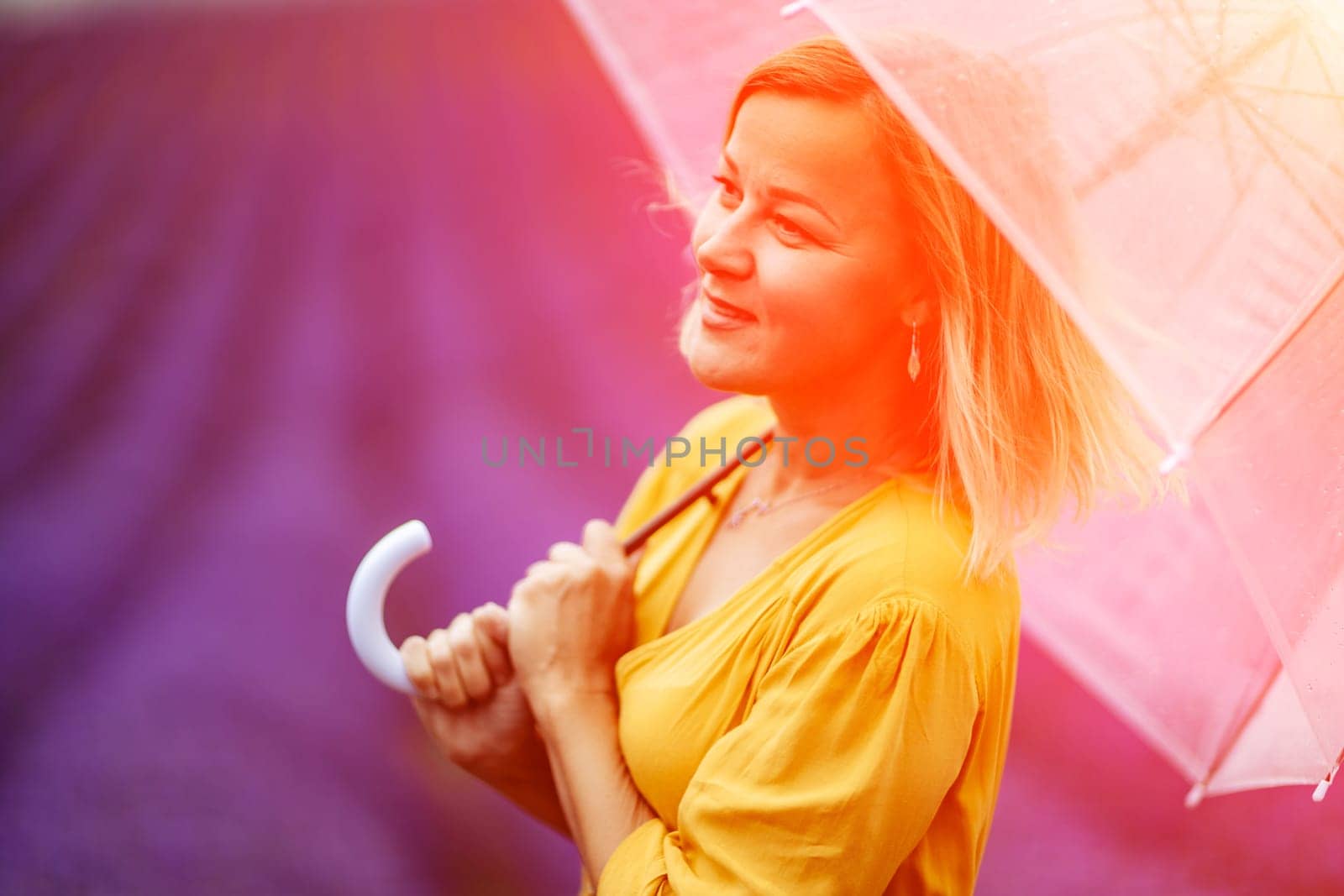 Woman lavender field. A middle-aged woman in a lavender field walks under an umbrella on a rainy day and enjoys aromatherapy. Aromatherapy concept, lavender oil, photo session in lavender.