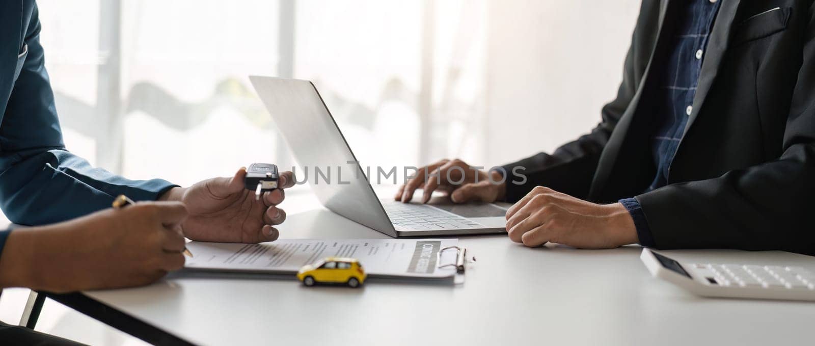 signing car insurance document or lease paper. Writing signature on contract or agreement. Buying or selling new or used vehicle. Car keys on table. Warranty or guarantee. Customer or salesman.