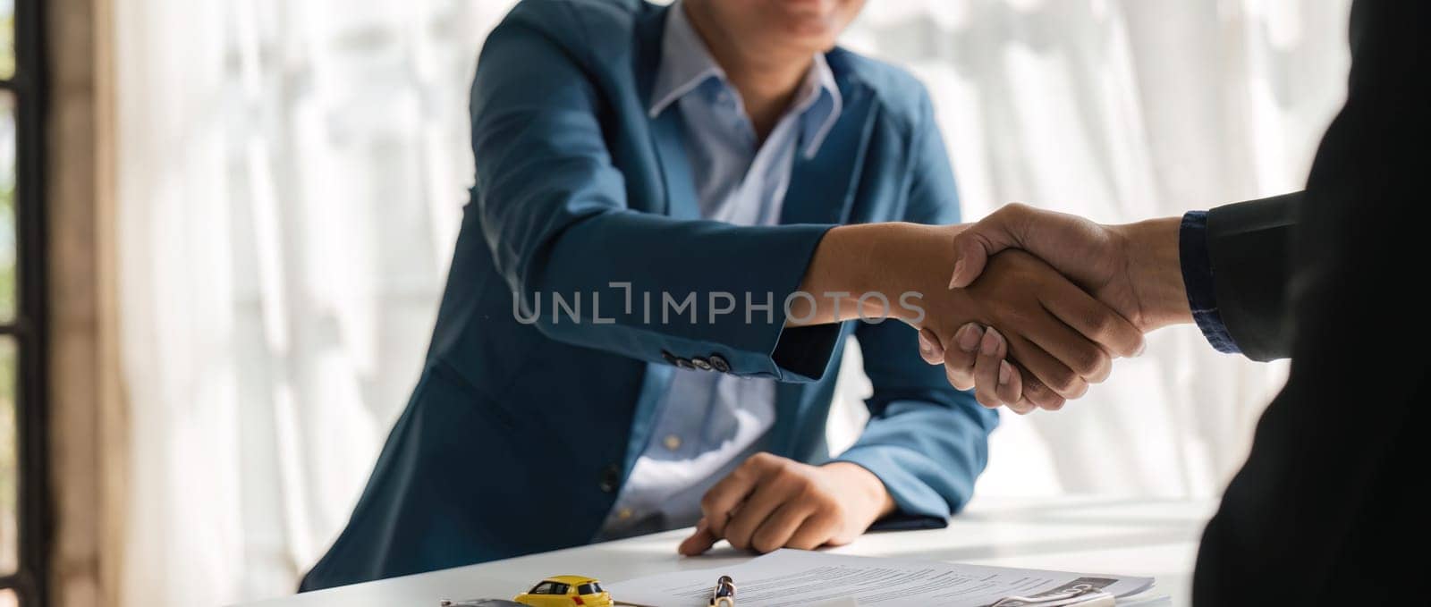 Handshake of cooperation customer and salesman after agreement, successful car loan contract buying or selling new vehicle.