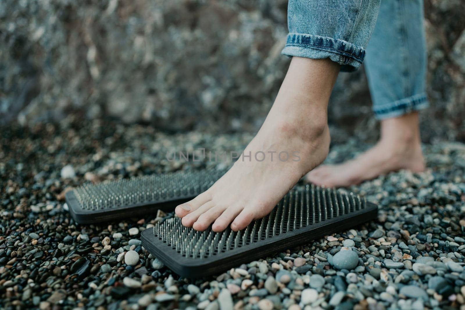 Sea Woman feet stepping on sadhu board during indian practice on the seashore. . Healthy lifestyle concept. tool for working out your inner state.