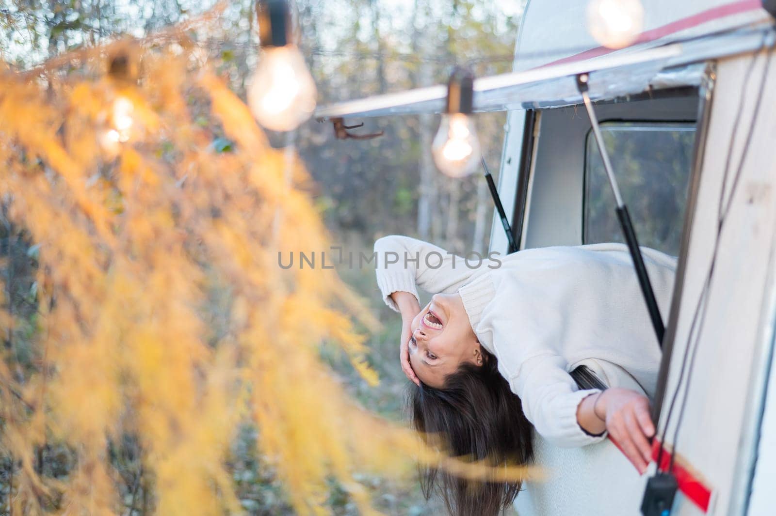 Caucasian woman peeking out of camper window