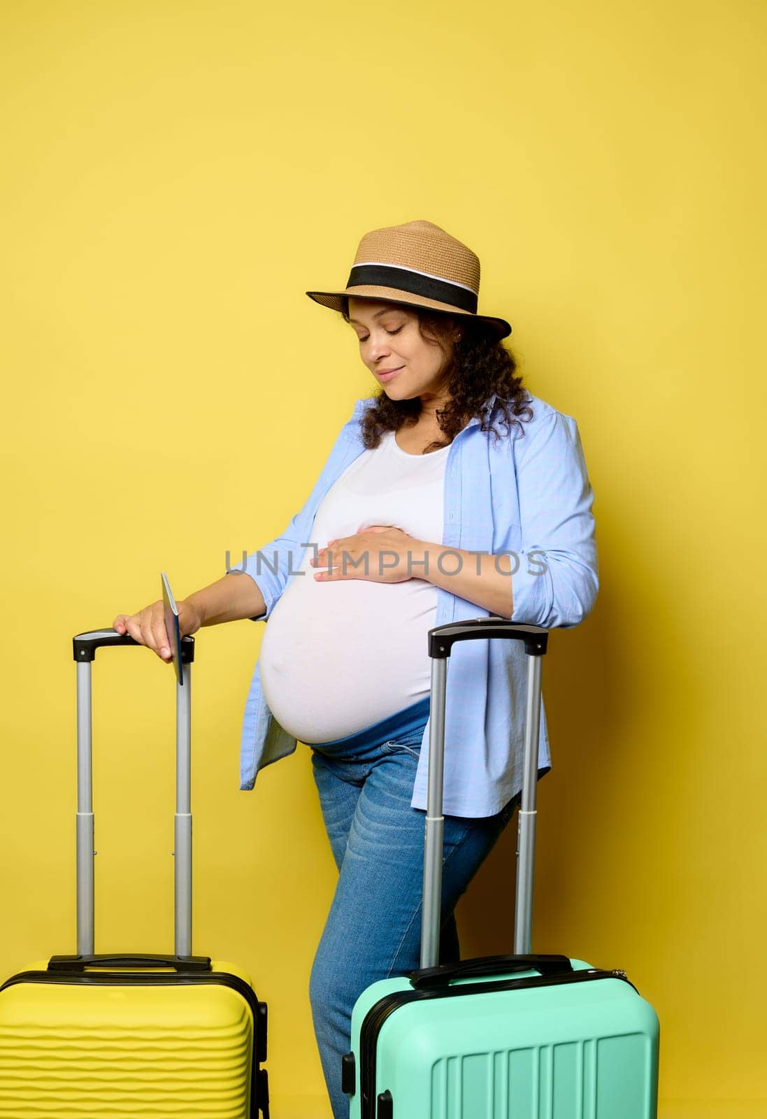 Happy pregnant woman strokes her belly, smiles enjoying to go on weekend getaway in pregnancy time, isolated background by artgf