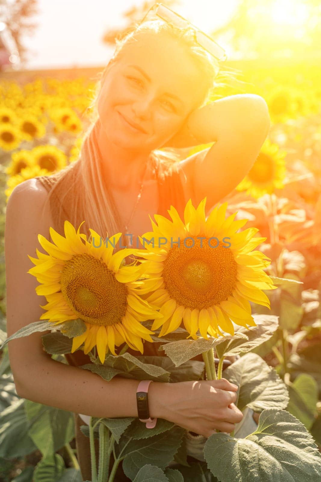 Beautiful woman in sunflower field at sunset enjoying summer nature. Attractive blonde with long healthy hair. by Matiunina