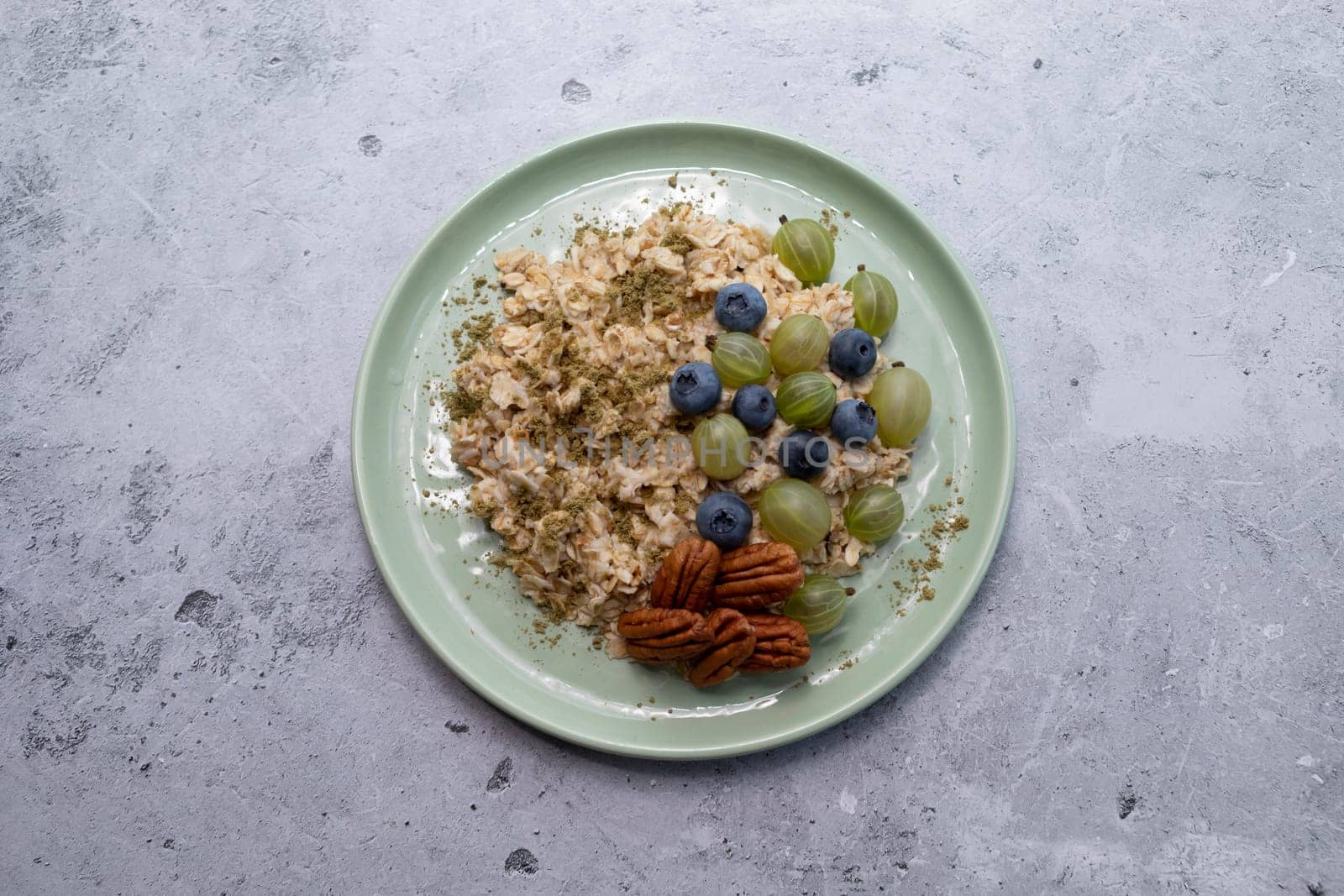 Oatmeal Porridge With Hemp Protein Powder and Berries, Nuts On Table. Healthy Breakfast With Plant-derived Protein from Cannabis Plant. Superfood, Healthy Meal. Horizontal Plane, Top View.