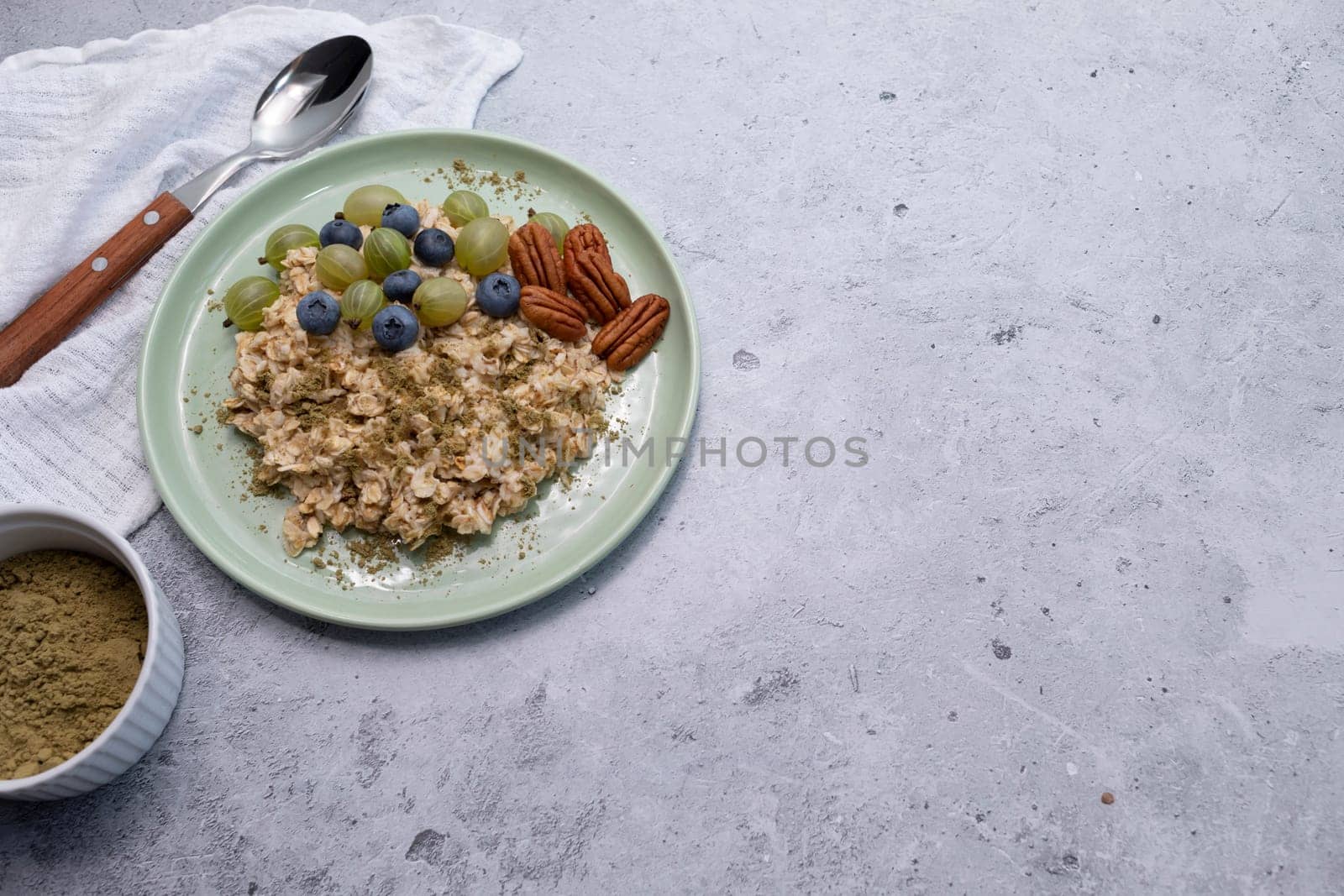 Top View Oatmeal Porridge With Hemp Protein Powder, Nuts, Berries, Bowl With Plant-derived Protein From Cannabis Plant, Spoon. Copy Space. Healthy Breakfast, Meal. Superfood. Horizontal Plane.